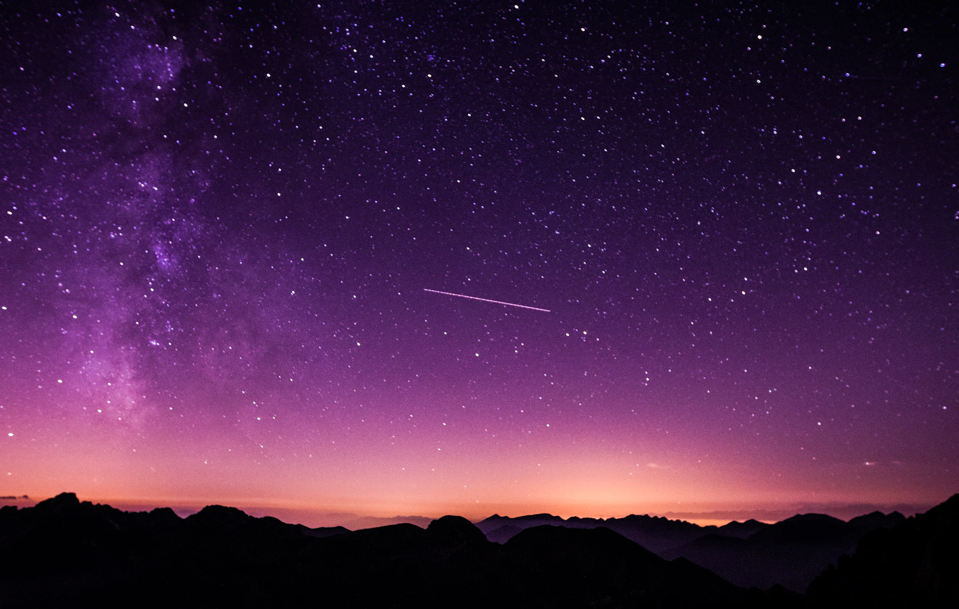 Céu estrelado profundo com tons violeta cobrindo o horizonte